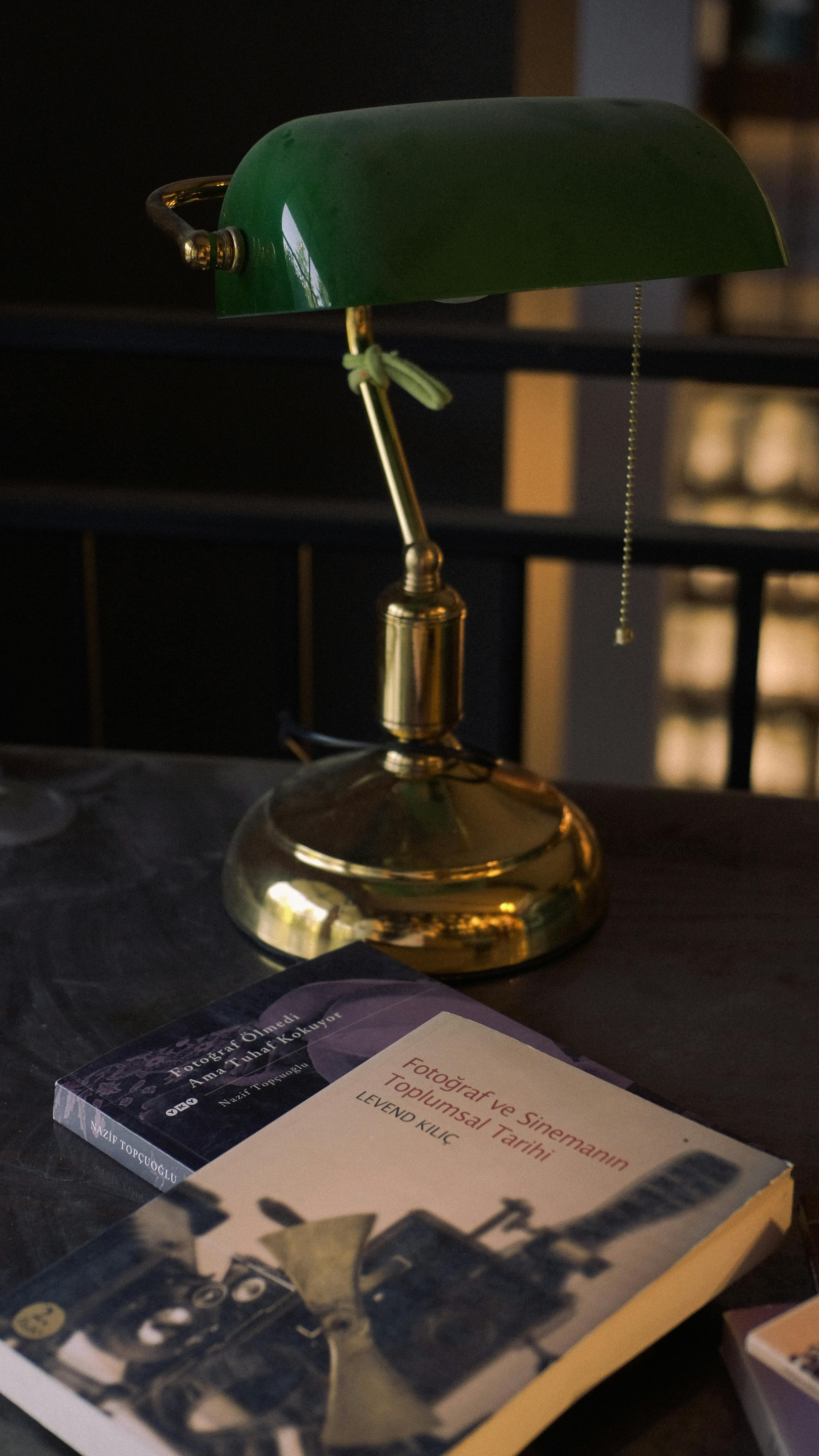 Brass reading lamp on a table with books