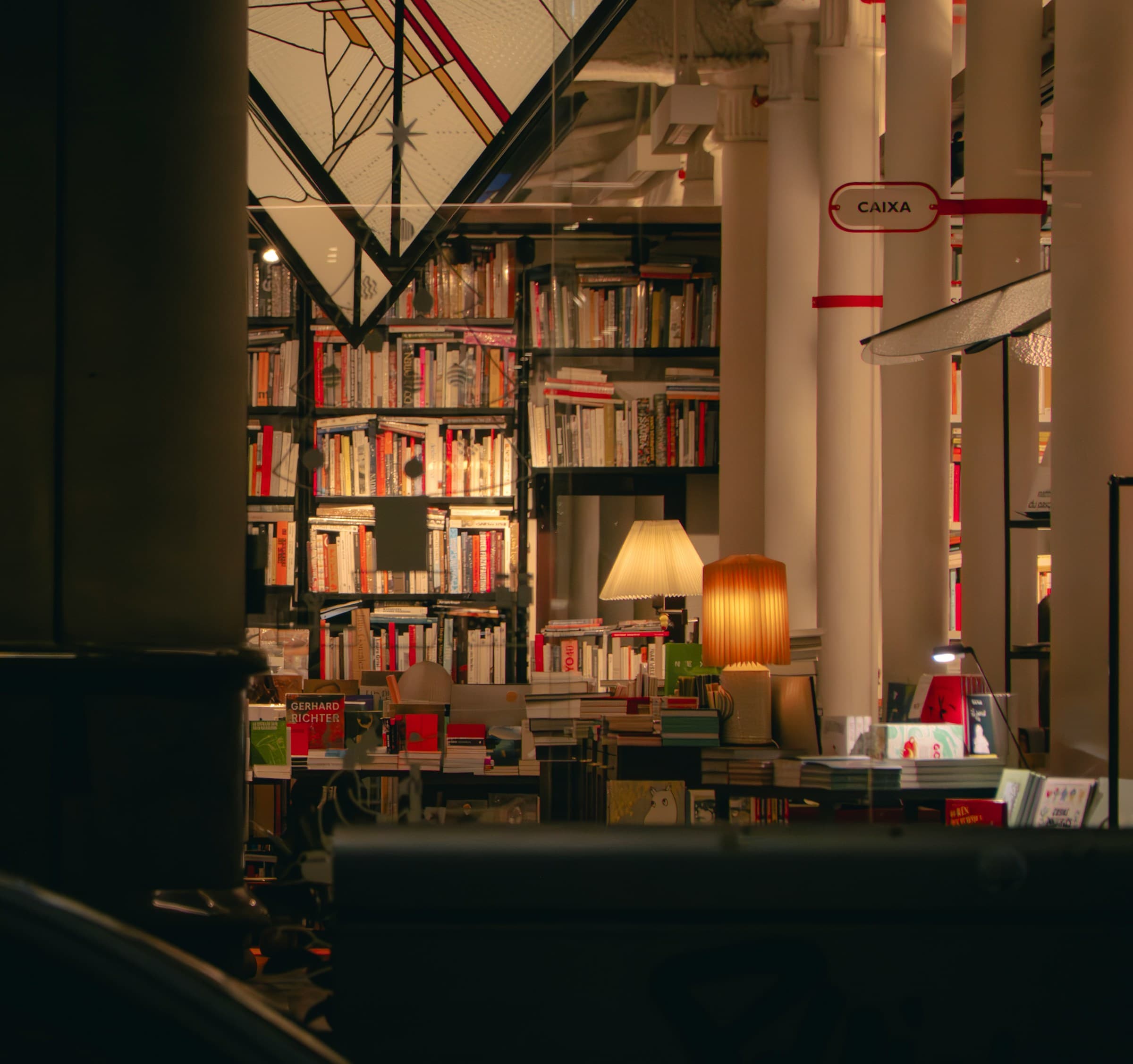 Warm evening bookshop with shelves and reading lamps