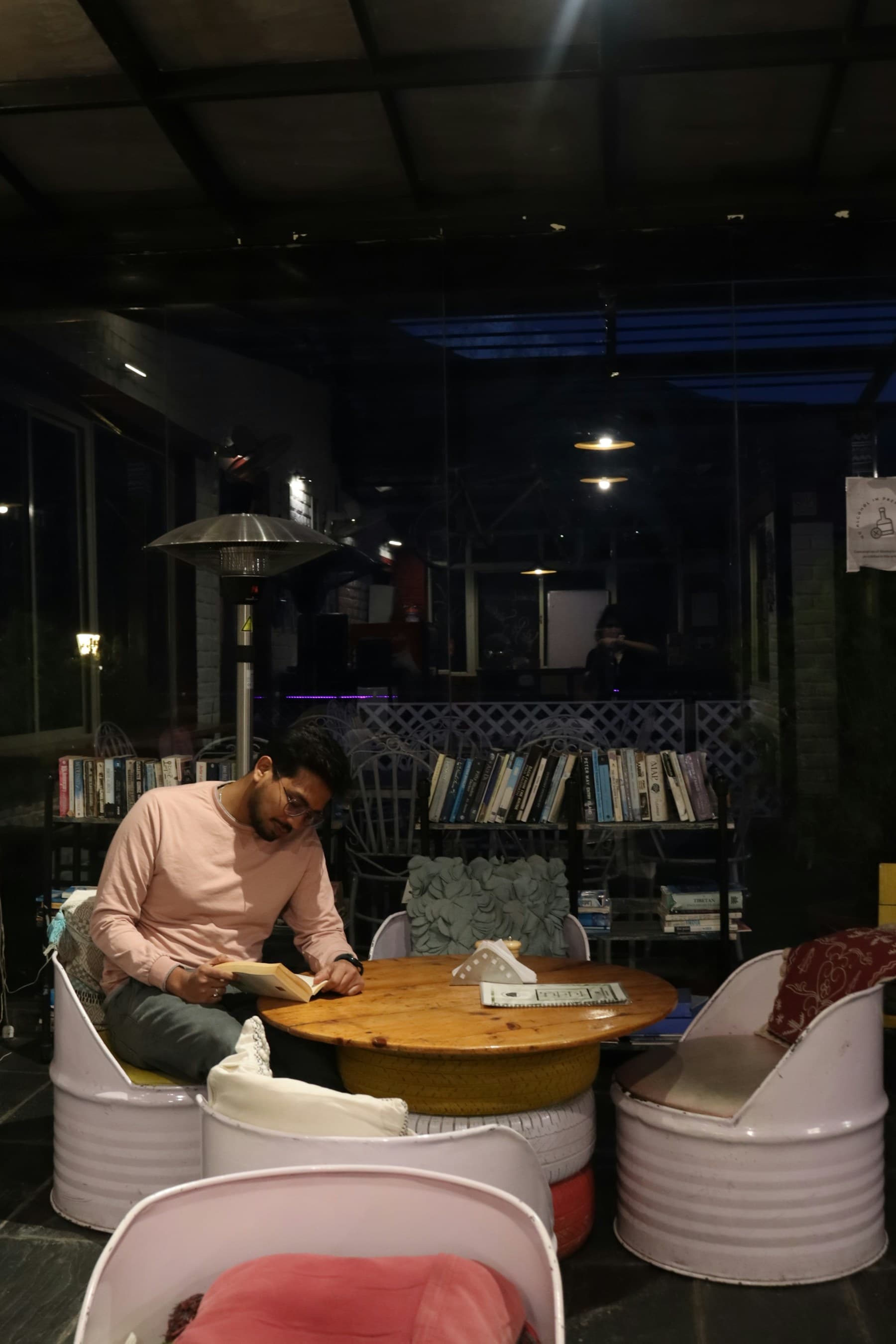 Adult reader at a warm table in a quiet evening interior