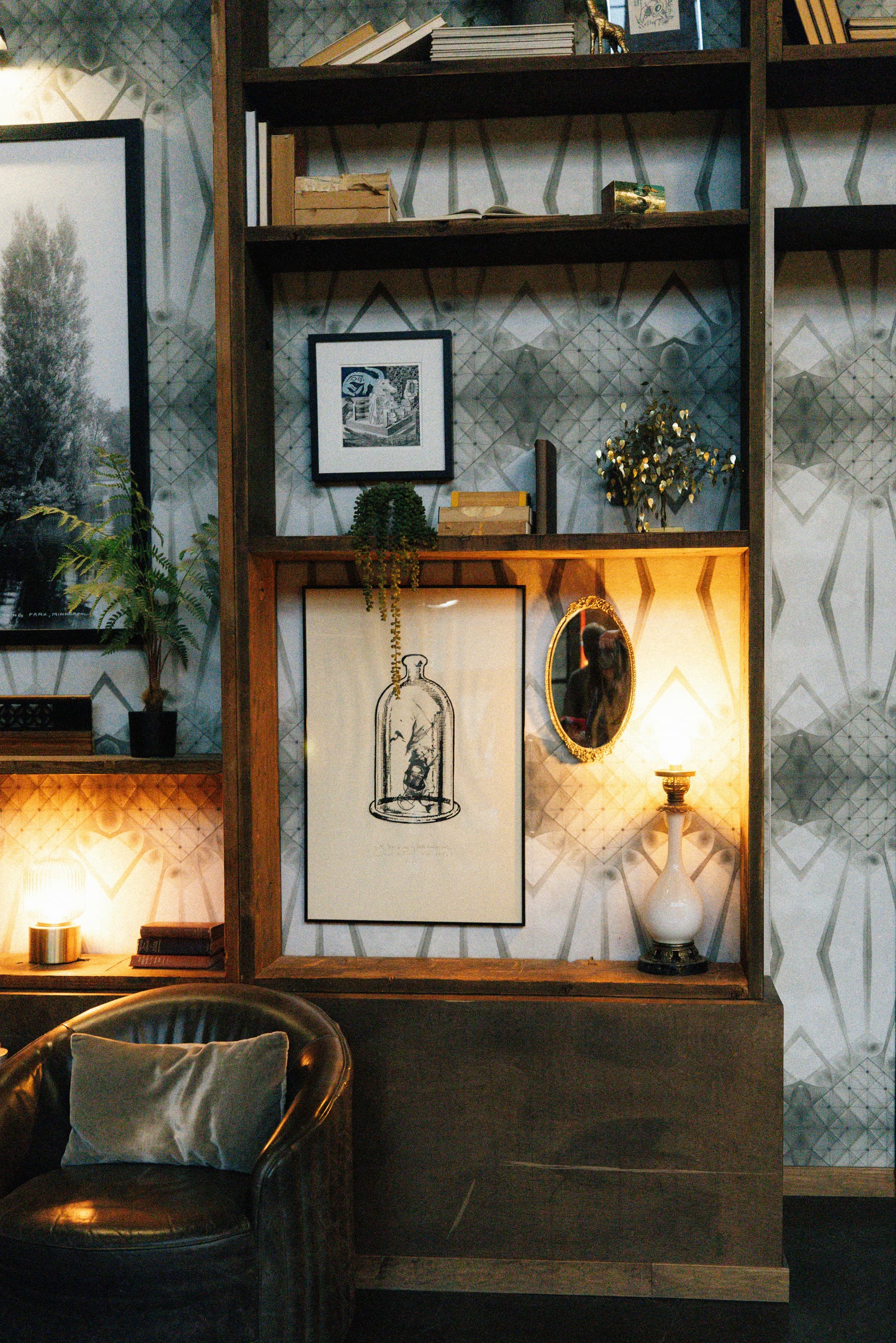 Warm private reading corner with shelves, framed art and a leather chair